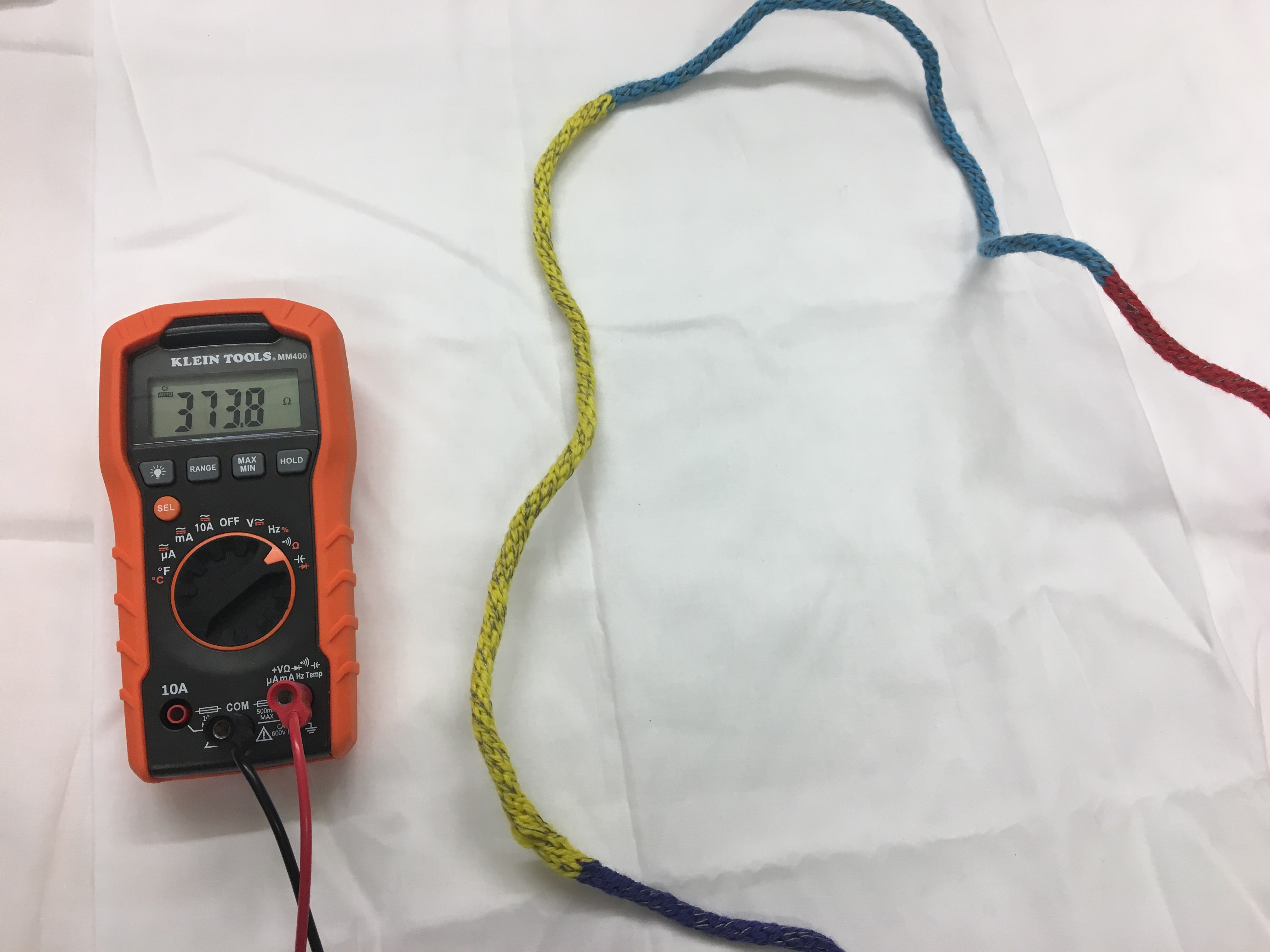 A multimeter measuring the electricity flowing through a knitted circuit