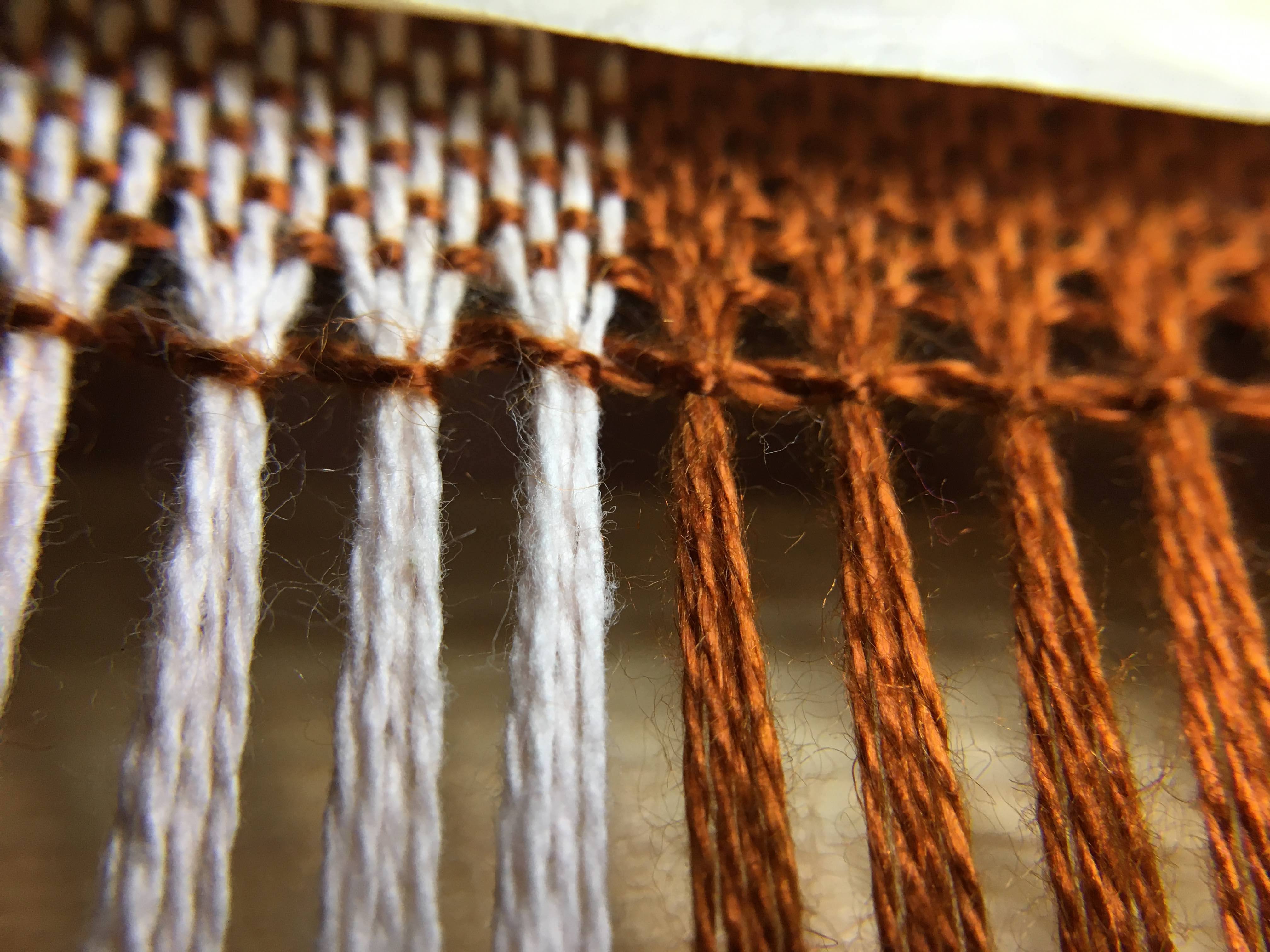 view of finished binding row, looks a bit separated by first warp row, might be fixed by selecting yarns about 3-4 rows up in stead of one. 